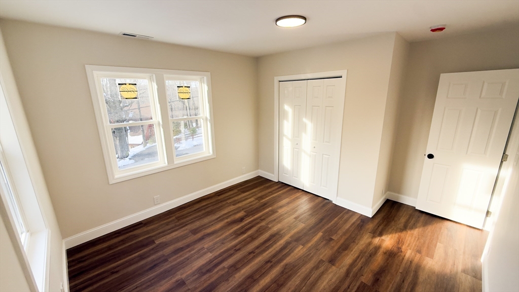 122 Copperfield Road Worcester, MA 01602 - Photo 16 of 28 a view of an empty room with wooden floor and a window