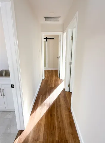a view of a hallway with wooden floor and staircase