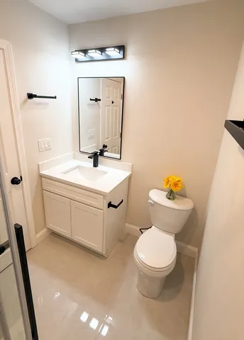 a bathroom with a sink a toilet a mirror and shower