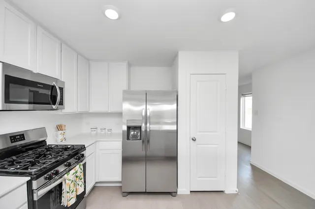 a kitchen with stainless steel appliances granite countertop a refrigerator and a stove top oven