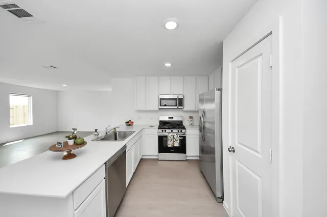 a kitchen with refrigerator and cabinets