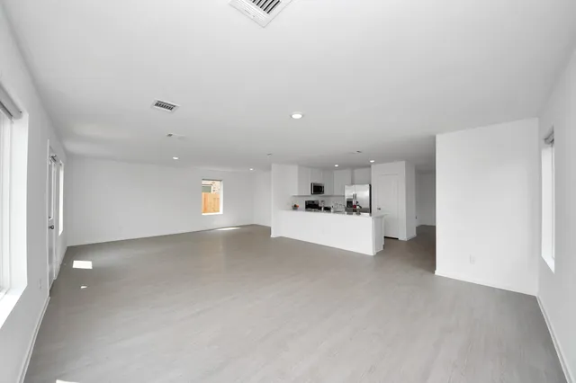 a view of empty room with kitchen