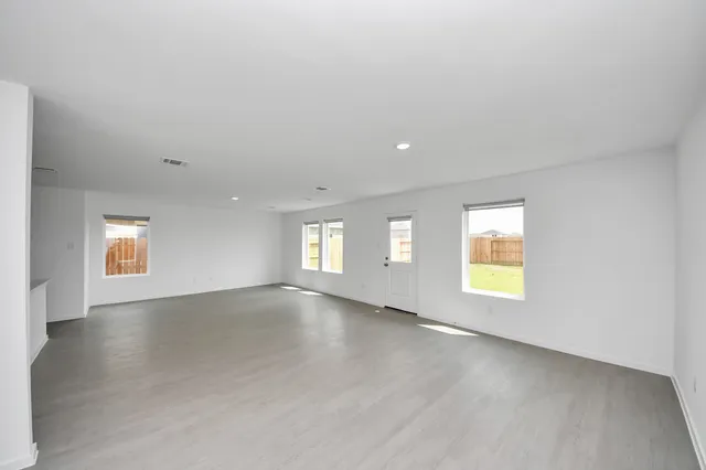 an empty room with window and wooden floor