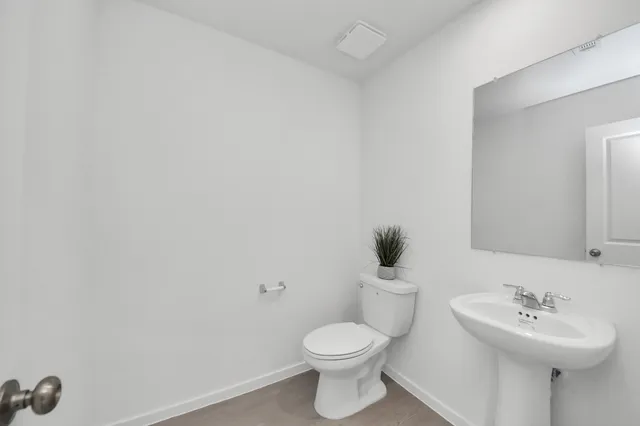 a bathroom with a sink mirror and toilet