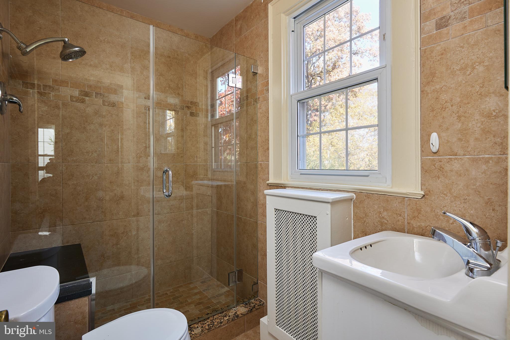 2913 24th Street North Arlington, VA 22207 - Photo 19 of 30 a bathroom with a sink toilet a mirror and shower