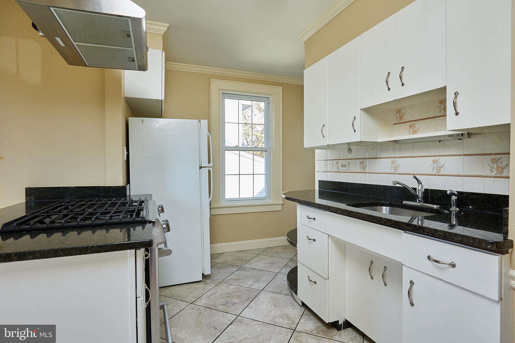 2913 24th Street North Arlington, VA 22207 - Photo 10 of 30 a kitchen with granite countertop a sink stove and cabinets