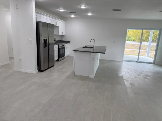 a view of a kitchen with a sink and a refrigerator