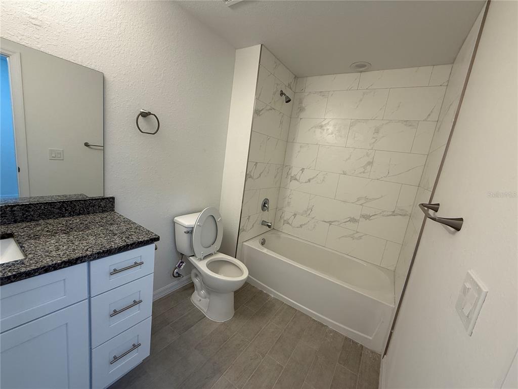 4971 Weatherton Street North Port, FL 34288 - Photo 21 of 30 a bathroom with a granite countertop sink toilet and shower