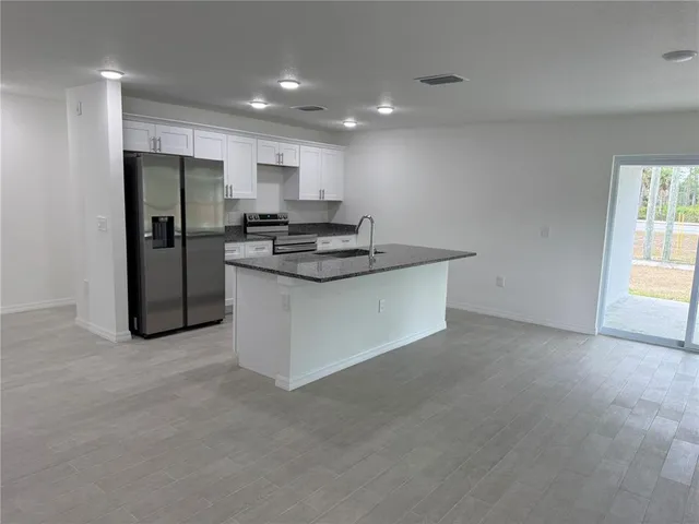a kitchen with stainless steel appliances granite countertop a stove and a refrigerator