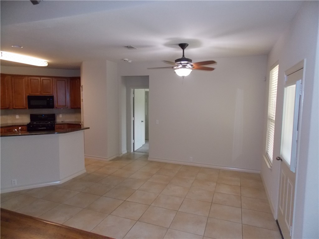 20961 Mandrake Drive Pflugerville, TX 78660 - Photo 16 of 34 a view of an empty room with a ceiling fan cabinet and a ceiling fan