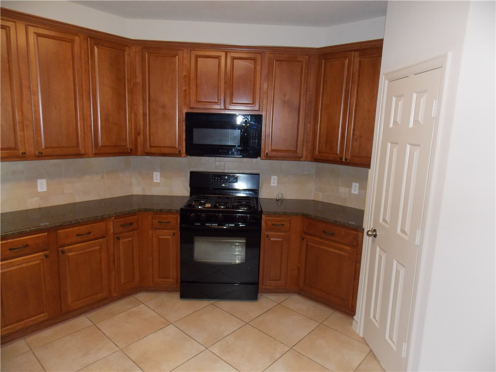 20961 Mandrake Drive Pflugerville, TX 78660 - Photo 18 of 34 a kitchen with stainless steel appliances granite countertop a refrigerator and a sink