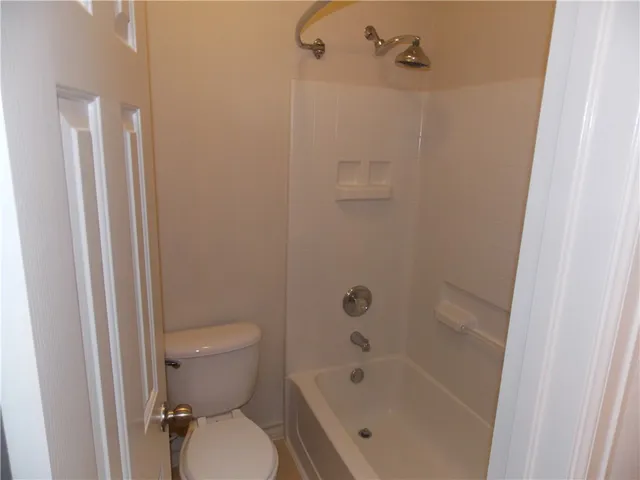 a white toilet sitting next to a bath tub