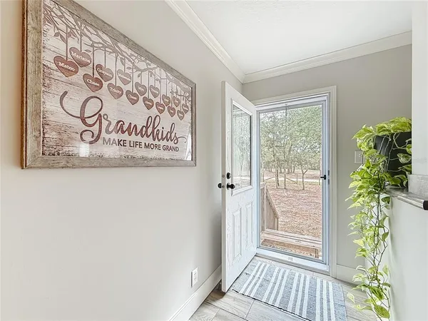 a living room with stainless steel appliances kitchen island granite countertop furniture a rug a stove and a window