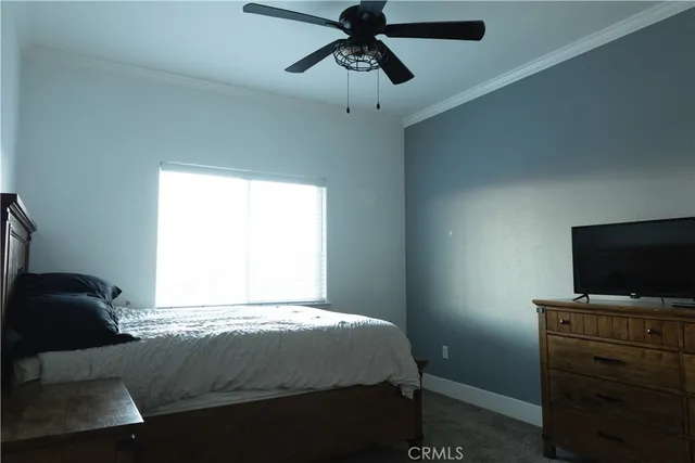 a bedroom with a bed and a flat tv screen on the dresser