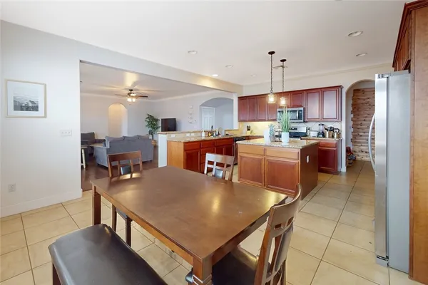 a kitchen with kitchen island a stove a sink a refrigerator and a dining table