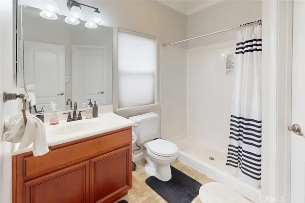 a bathroom with a sink a toilet a mirror and shower