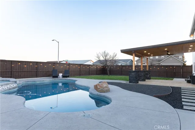 a swimming pool with outdoor seating and yard