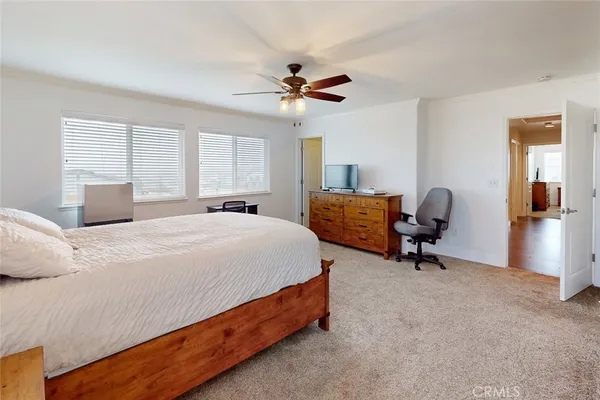 a spacious bedroom with a bed and a chandelier