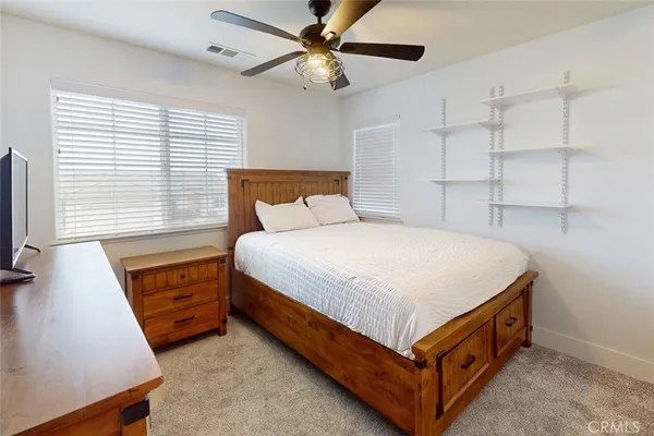 a spacious bedroom with a bed and a flat screen tv