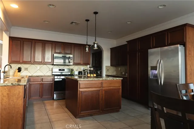 a kitchen with stainless steel appliances granite countertop a sink stove refrigerator and cabinets