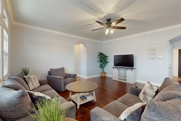 a living room with furniture a flat screen tv and a window
