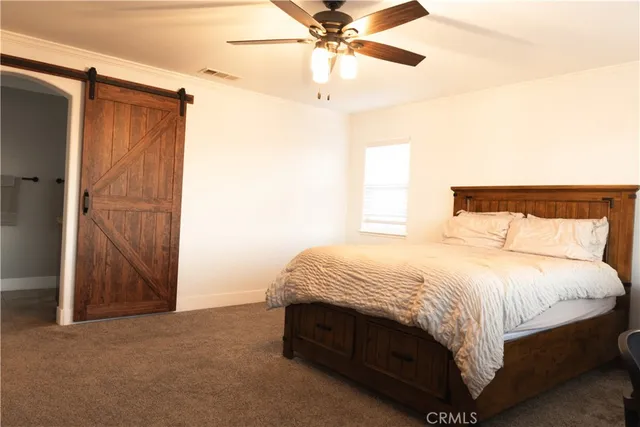 a bed sitting in a bedroom next to a window and a chandelier