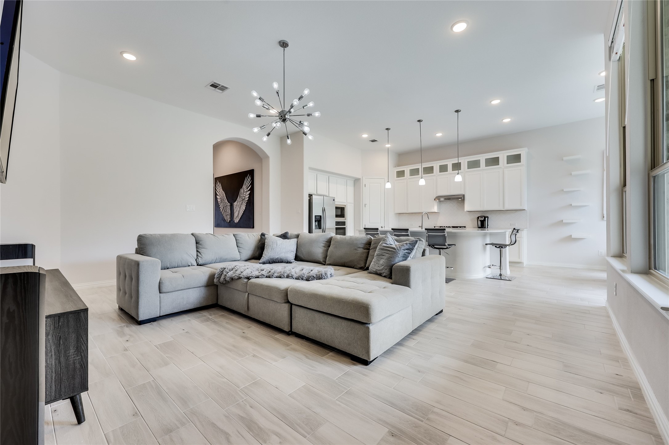 7705 Pace Ravine Drive Lago Vista, TX 78645 - Photo 6 of 40 Living room featuring light wood-type flooring, suspended lighting, and arched walkways