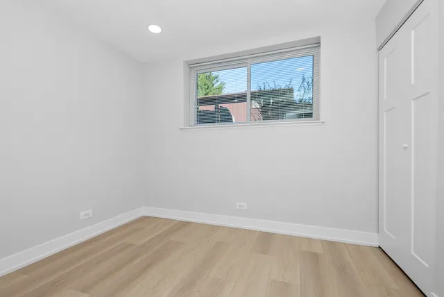 an empty room with wooden floor and window