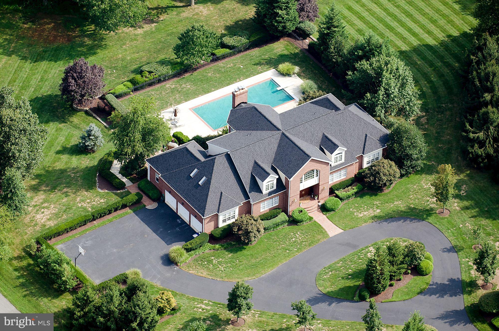 an aerial view of a house with a big yard and large trees