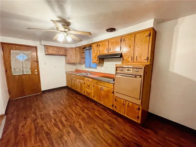 a kitchen with stainless steel appliances granite countertop a refrigerator a stove and a wooden floors