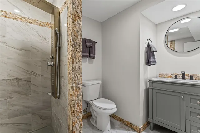 a bathroom with a toilet a sink and shower