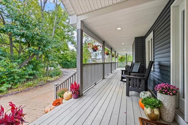 a balcony with wooden floor and outdoor seating
