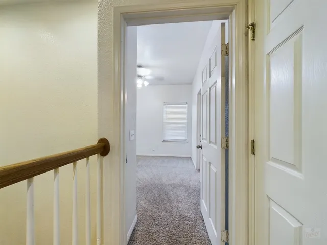 a view of a hallway with a closet and wooden floor