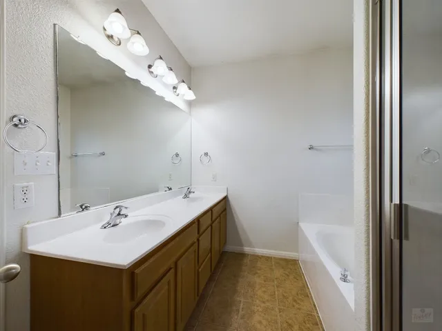 a bathroom with a sink a large mirror and vanity