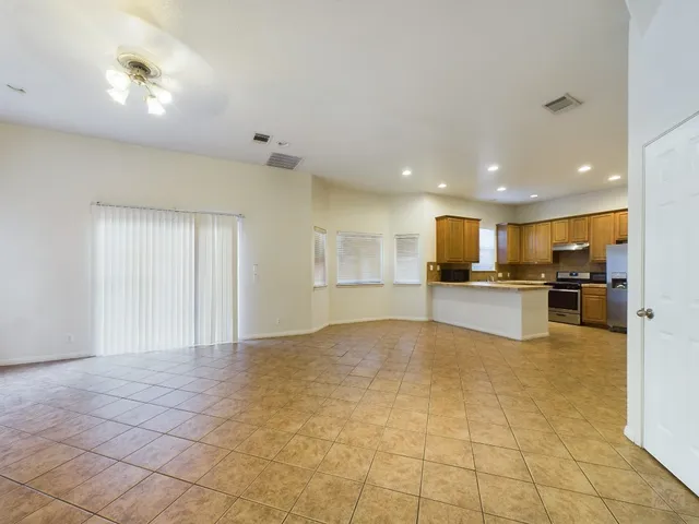 a view of kitchen with kitchen island stainless steel appliances refrigerator sink and cabinets