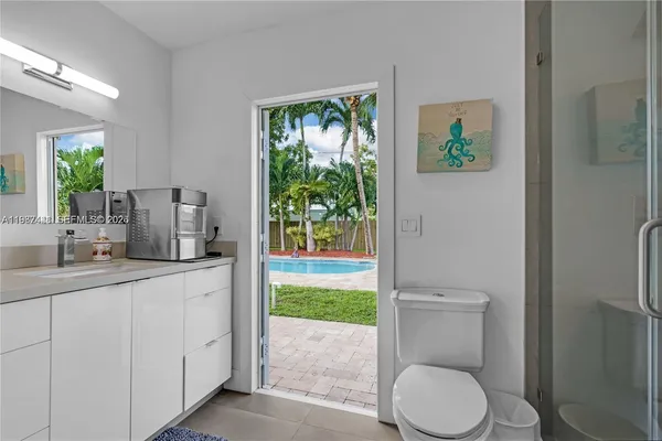 a bathroom with a granite countertop toilet sink and mirror