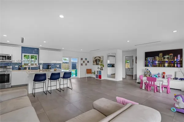 a living room with furniture and kitchen view