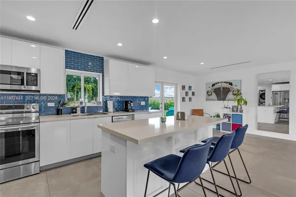 a kitchen with stainless steel appliances kitchen island granite countertop a sink and cabinets