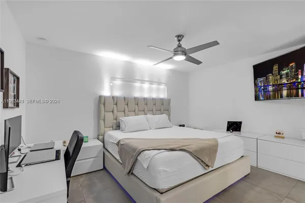 a bedroom with a white bed desk and chair