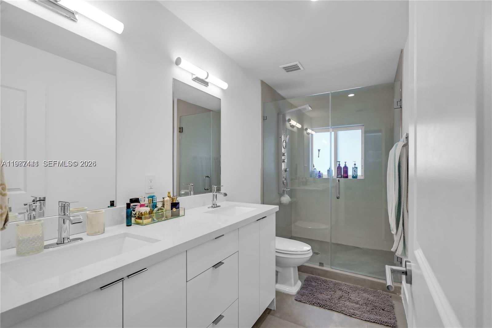 10471 Southwest 164th Street Miami, FL 33157 - Photo 10 of 15 a bathroom with a double vanity sink mirror double shower and a toilet