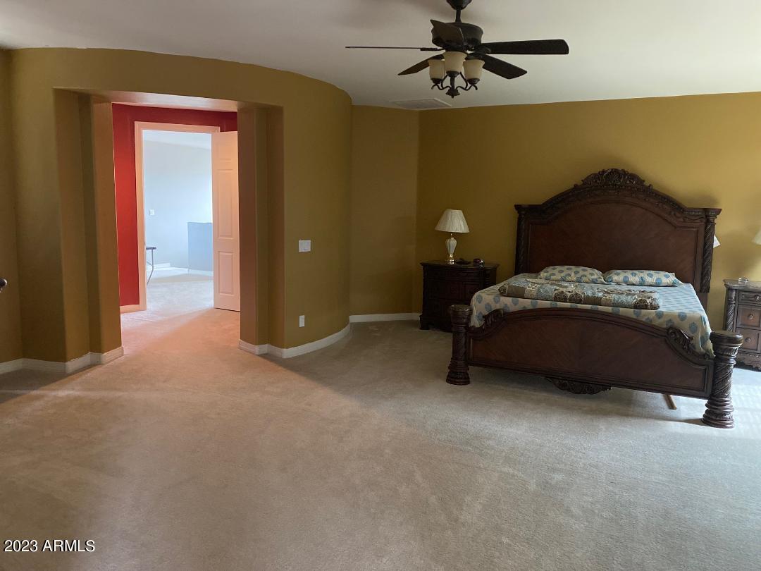 2757 East Powell Way Gilbert, AZ 85298 - Photo 11 of 29 a spacious bedroom with a bed and a ceiling fan