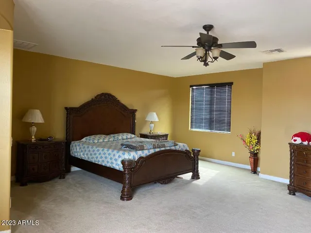 a bedroom with a bed and a ceiling fan