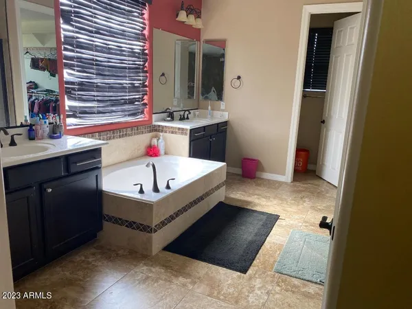 a bathroom with a tub sink mirror and vanity