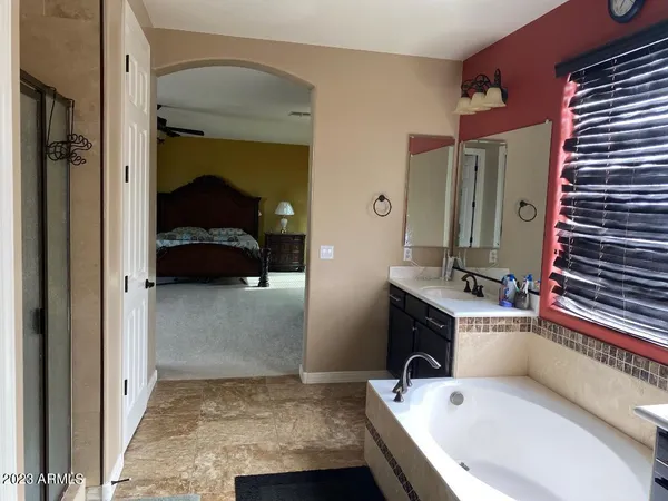 a bathroom with a tub sink and mirror
