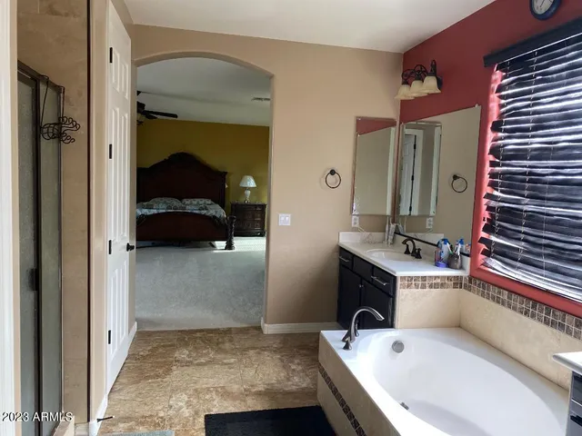 a bathroom with a tub sink and mirror