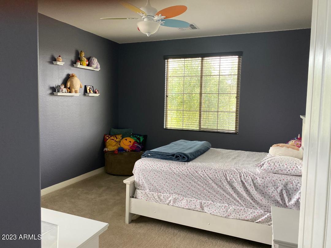 2757 East Powell Way Gilbert, AZ 85298 - Photo 20 of 29 a bedroom with a bed and a chandelier