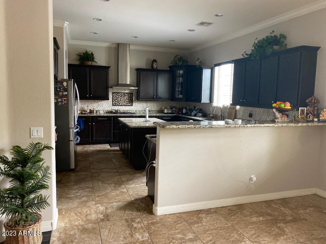 2757 East Powell Way Gilbert, AZ 85298 - Photo 6 of 29 a kitchen with kitchen island granite countertop a sink appliances and cabinets