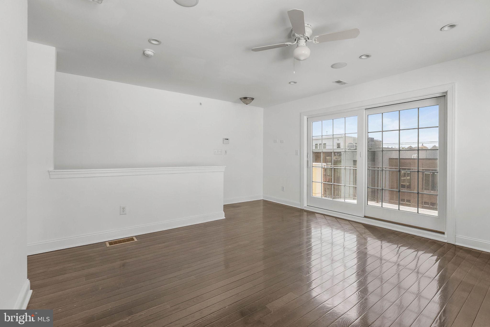 1015 North 3rd Street, Unit H Philadelphia, PA 19123 - Photo 13 of 27 an empty room with wooden floor and windows