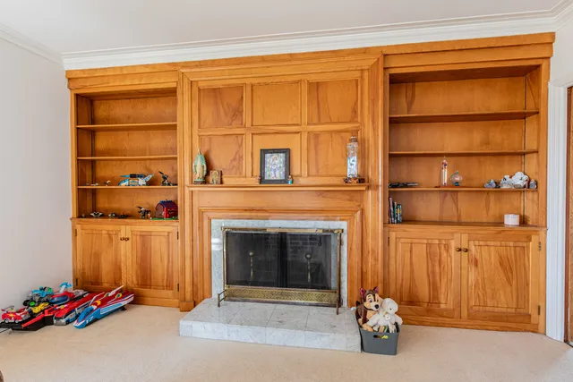 a living room with a fireplace cabinet and a fireplace
