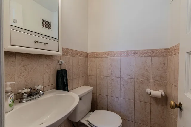 a bathroom with a sink a toilet and mirror